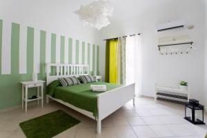 1 dormitorio con 1 cama con rayas verdes y blancas en Le Scale Apartment, en Palermo
