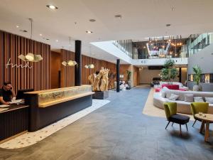 a lobby of a hotel with couches and tables at Tailormade Hotel SIHLPARK Schindellegi in Schindellegi