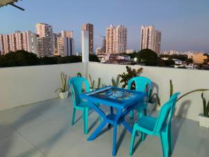 a blue table and chairs on a balcony with a city skyline at Hospedaje Torices Cartagena in Cartagena de Indias