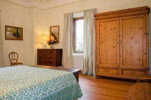 ein Schlafzimmer mit einem Bett, einer Kommode und einem Fenster in der Unterkunft Casale Cipresso in Migliarino