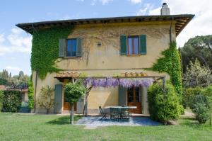 ein Haus mit einem Tisch davor in der Unterkunft Casale Pino in Migliarino