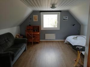 Camera mansardata con divano e finestra. di Kråkeskogsgården, nature in town a Osby