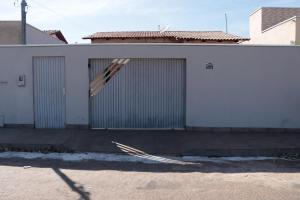 a white building with ajar doors on the side of it at Casadapraça in Goianésia
