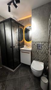 Un baño con ducha, inodoro y lavabo. en Люкс 2х комнатная квартира, en Taraz