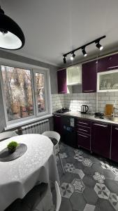 cocina con mesa y cocina con armarios morados en Люкс 2х комнатная квартира, en Taraz