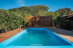 een zwembad in een achtertuin met een houten terras bij Chalés Elegantes e Completos em Imbituba - REL in Praia do Rosa
