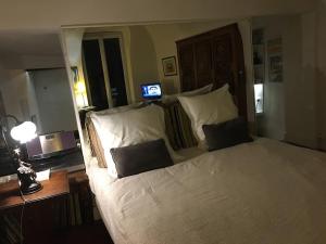 Un dormitorio con una gran cama blanca con dos almohadas. en Dans village médiéval piétonnier, Suite exécutive vue mer exceptionnelle, en Roquebrune-Cap-Martin