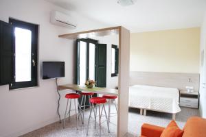 a room with a bed and a table with red stools at RTA Palazzo Judica in Palazzolo Acreide