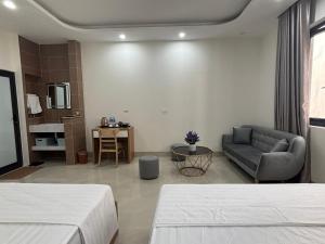 a hotel room with two beds and a couch at Ha Noi Smile Home in Ðình Loan