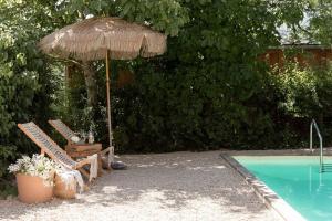 ChampignollesTraditional Apartment In The Heart Of Burgundy的游泳池旁的遮阳伞和椅子