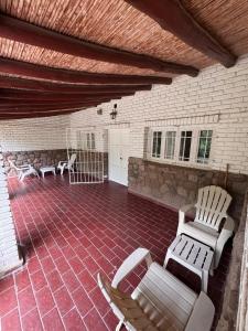 卢汉德库约LA CASONA DE LU的一个摆放着白色椅子、铺着砖地板的露台 更多22张照片