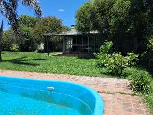 a swimming pool in a yard with a house at Casa Quinta Las Palmeras in Gualeguay