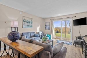 a living room with a couch and a table at Torch Lake Vista A-Ga-Ming Golf Retreat 741 in Creswell +25 photos