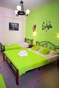 two beds in a room with green walls at Olympos Pension in Rhodes Town