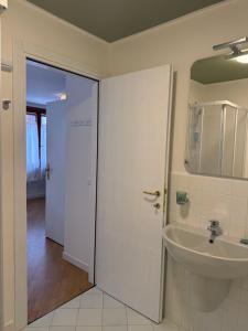 a bathroom with a sink and a white door at Appartamenti Anna in Sirmione