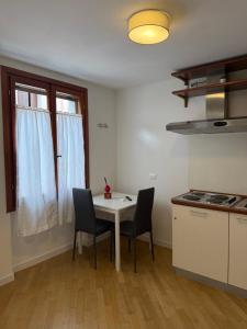 a kitchen with a white table and two chairs at Appartamenti Anna in Sirmione