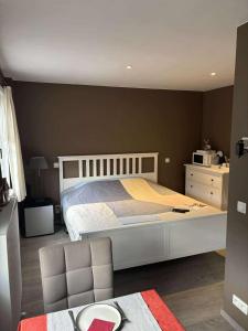 Un dormitorio con una cama grande y una silla en Break@Bruges, en Brujas