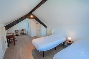 ein Schlafzimmer mit einem Bett und einem Schreibtisch in einem Zimmer in der Unterkunft Maison Le Damier - Proche Center Parcs et Lamotte Beuvron - 3 chambres in La Ferté-Saint-Aubin