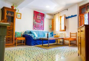 a living room with a blue couch and a table at Vilamurada • Terraza con vistas al casco antiguo in Denia