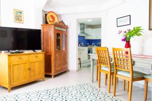 a kitchen with a table and chairs and a tv at Vilamurada • Terraza con vistas al casco antiguo in Denia +39 photos