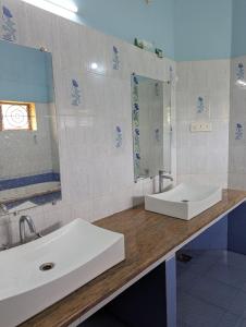 un bagno con due lavandini e uno specchio di Bunk You Hostel a Gokarna