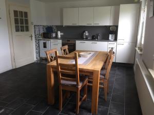 una cucina con tavolo da pranzo e sedie in legno di Ferienwohnung Feldhofs a Medebach