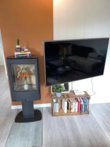 a tv sitting in a living room next to a couch at Stylish toppleilighet med flott utsikt - sentralt in Vossevangen +16 photos