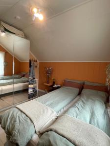 a bedroom with two beds and a mirror at Stylish toppleilighet med flott utsikt - sentralt in Vossevangen