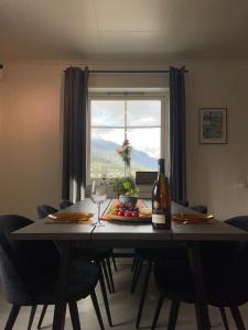 a table with a bottle of wine and a glass at Stylish toppleilighet med flott utsikt - sentralt in Vossevangen