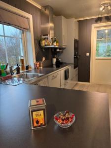 eine Küche mit einer Theke mit einer Schüssel Essen drauf in der Unterkunft Stylish central penthouse - River views in Vossevangen