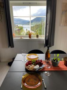 a table with a plate of food and a window at Stylish toppleilighet med flott utsikt - sentralt in Vossevangen