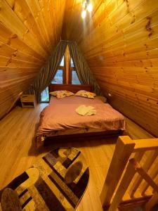 a bedroom with a bed in a log cabin at Cabana A frame Casa Edy in Călimăneşti