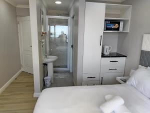 a small bedroom with a bed and a sink at Cosmic View Lodge in East London