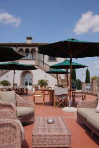 a patio with chairs and tables and umbrellas at Poggio al Casone in Crespina