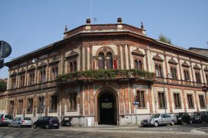 an old building with cars parked in front of it at Suitime in Milan