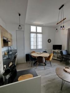 a kitchen and living room with a table and chairs at Trésor T3 plein coeur la Baule in La Baule