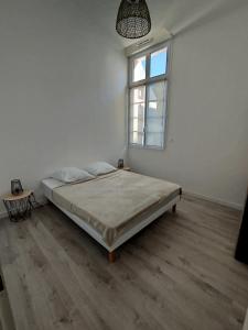 a white room with a bed and a window at Trésor T3 plein coeur la Baule in La Baule