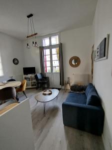 a living room with a blue couch and a table at Trésor T3 plein coeur la Baule in La Baule +13 photos