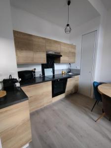 a kitchen with wooden cabinets and a wooden table at Trésor T3 plein coeur la Baule in La Baule