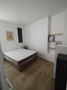 a bedroom with a bed in the corner of a room at T2 d'Anne proche plage et marché in La Baule