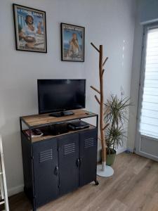 a tv on a cabinet in a living room at T2 d'Anne proche plage et marché in La Baule