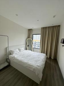 una camera da letto con un letto bianco e una finestra di Căn nhà nhỏ a Long Bình