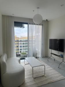 un soggiorno con sedia bianca e TV di Căn nhà nhỏ a Long Bình