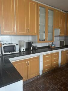 uma cozinha com armários de madeira e um micro-ondas em Hotel Araras em Manaus mais 19 fotografias