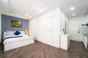 ホーチミン・シティにあるSabina Residence - HCMの白いベッドと青い壁が備わるベッドルーム1室が備わります。