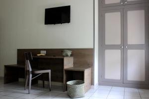 Habitación con escritorio y TV en la pared. en Hôtel Poste et Champanne, en Brioude