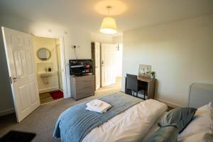 Queens Court Ensuite Studio في ستوك أون ترينت: غرفة نوم بها سرير وتلفزيون