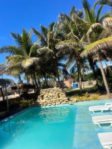 una piscina con palme sullo sfondo di Bali Lodge Máncora - Playa, Piscina & Desayuno a Máncora