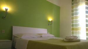 una camera verde con un letto con due asciugamani di Al Borgo Village a Pietra Ligure