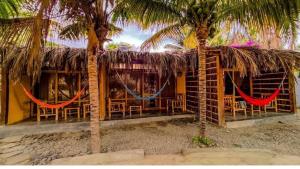 un resort con amache di fronte a un edificio di Bali Lodge Máncora - Playa, Piscina & Desayuno a Máncora